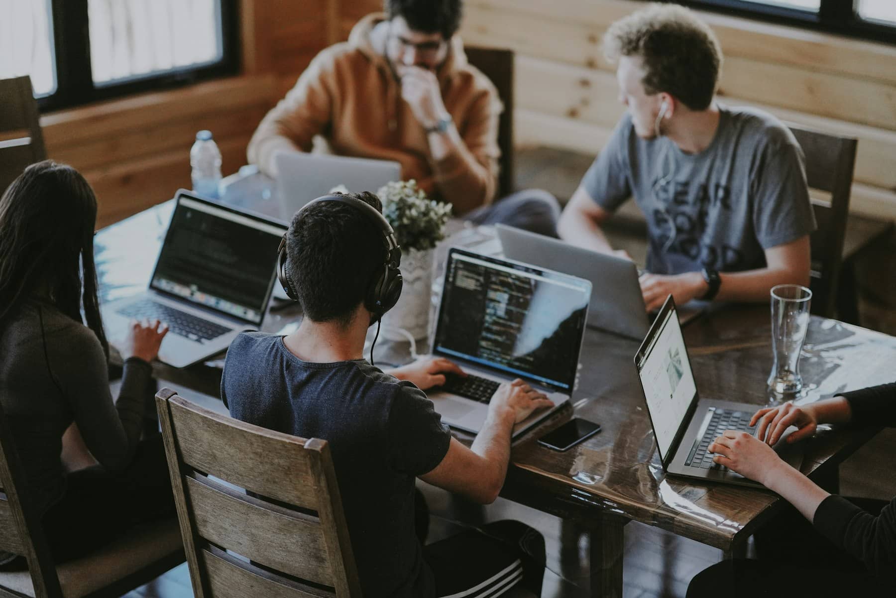 Équipe au travail autour d'une table, sur ordinateurs